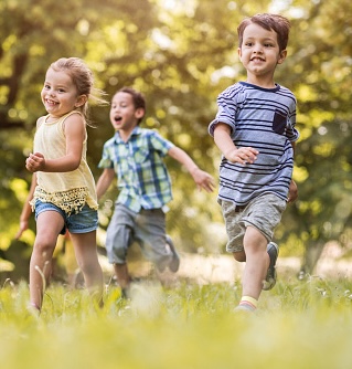 Jin Shin Jyutsu group of happy kids having fun while running in the park.